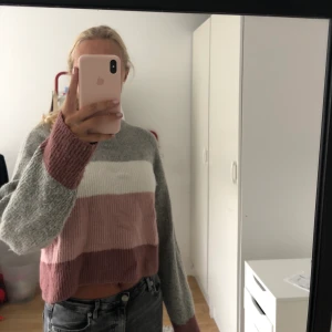 Randig stickad tröja  - En grå vit o rosarandig tröja från Nelly, väldigt mjukt material och den är i storlek S. 