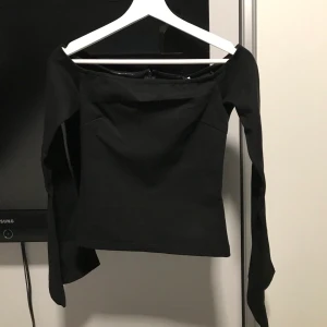 Offshoulder tröja - Svart offshoulder tröja med vida armar från NA-KD. Aldrig använd därav prislappen kvar. Storlek S men förlusten för mig så skulle påstå att det är mer en XS