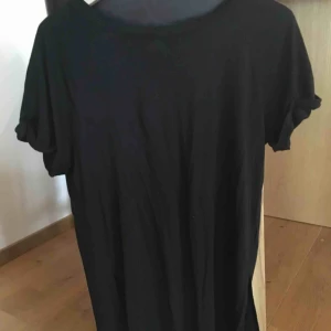  - Snygg kort svart klänning. Öppen nere i sidorna, fin med en svart underklänning