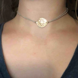  - Choker halsband med vitt band och gulddetaljer. Den är 35 cm när man mäter den. Men den är elastiskt. Köparen betalar frakten