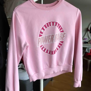  - Rosa sweatshirt med muddar & tryck på framsidan. I storlek XS & något croppad från H&M. Använd ett FÅTAL gånger och tryckets kvalitét är som NYTT!