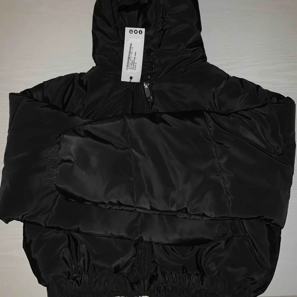En svart croppad puffer jacket från boohoo. Helt ny med lappen kvar. Frakt tillkommer, antingen spårbart eller med frimärke. Köpt för närmare 500kr. . Jackor.
