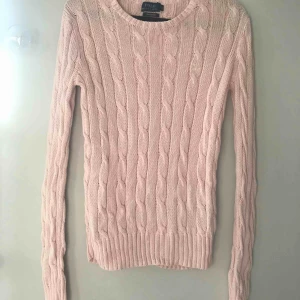  - Säljer en ljusrosa kabelstickad tröja från Ralph Lauren. Materialet är ”pima cotton” vilket är västindisk bomull. Jag säljer den eftersom att jag aldrig använder den.