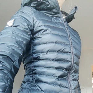  - Lätt och skön höst och vårjacka säljes pga av för liten storlek. Köptes för en månad sedan för 1399 kr och har endast använts två gånger (till och från jobbet).  MATERIAL & SKÖTSEL Material: 100% nylon Foder: 90% dun, 10% fjäder Foder: 100% nylon Fodertjocklek: Varmt foder Icke-textila delar av animaliskt ursprung: Ja Skötselråd: Torktumlas ej, 30°C maskintvätt, skontvätt PRODUKTINFORMATION Krage: Kapuschong med dragsko Förslutning: Dragkedja Fickor: Fickor med dragkedja, innerfickor Detalj huva: Kapuschong med dragsko, fodrad kapuschong Mönster: Enfärgat