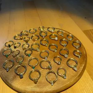 Hemmagjorda ringar av guldig metalltråd och stenar. Finns i lite större och lite mindre storlekar som man ser på bilden. Är du intresserad ta en skärmdump av ringarna och ringa in den/de som du vill ha! 1 ring för 15kr, 4 för 50kr och om du vill ha mer än 4 kostar det 10kr för varje extra ring. Köper du många kan du själv välja vilka ringar du vill ha eller så får du så många du köper fast jag väljer ut dem!