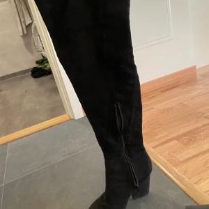 Overknee boots - Säljer ett par svarta overknee boots i mocha imitation, aldrig använda. Storlek 37/38