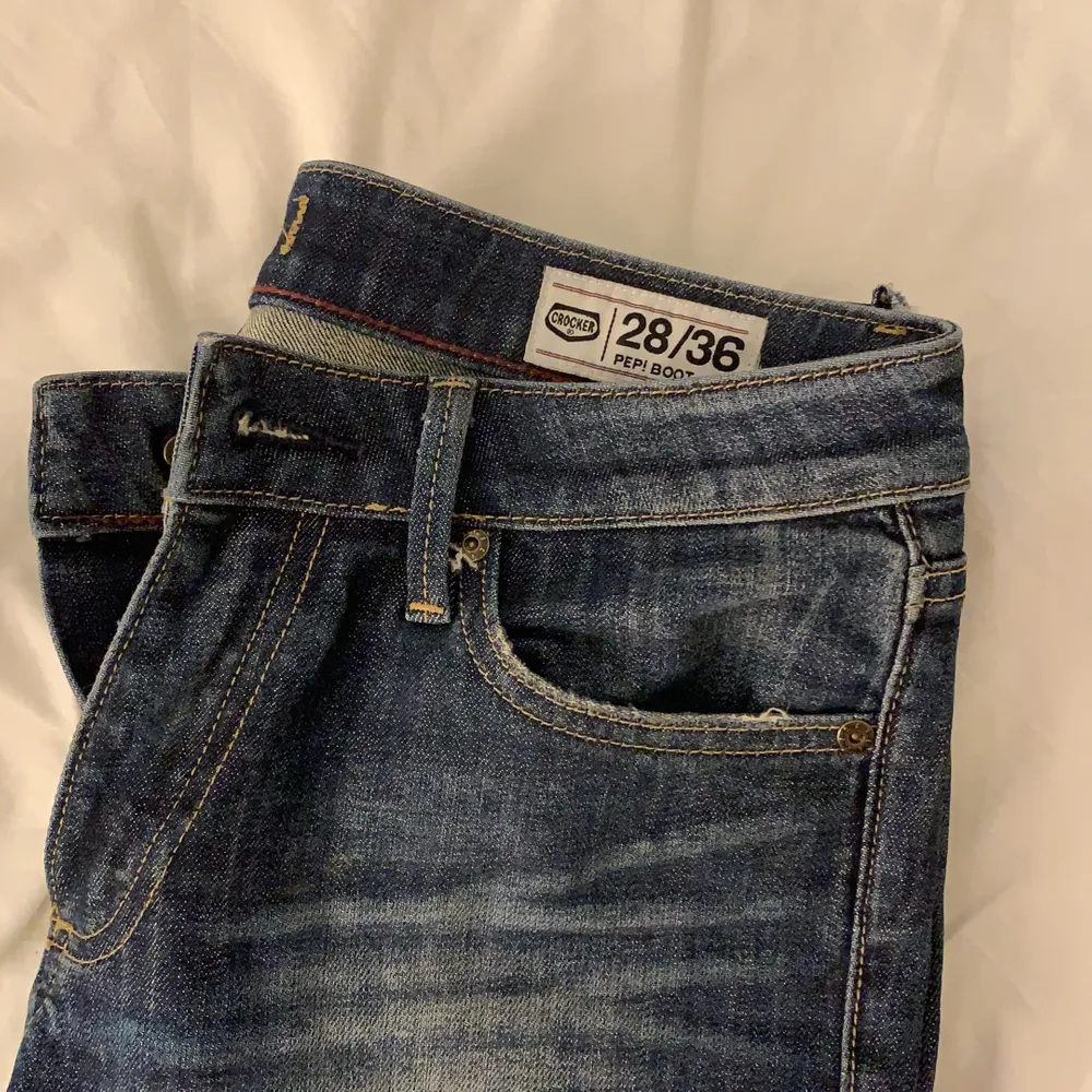 Ett är mörkblåa bootcut jeans från Crocker, JC. Strl 28/36. De är i bra skick utom att de har ett litet hål ovanför ena bakfickan (se bild). Jeans & Byxor.