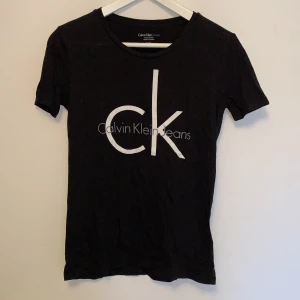 Calvin Klein t-shirt med tryck, storlek XS - Svart Calvin Klein t-shirt med vitt och grått tryck, storlek XS, riktigt bra skick