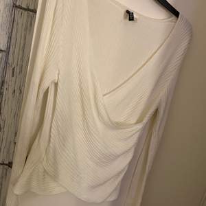 En vit omlott tröja, som har använts 3 gånger högst, den är i ett ribbat tyg och är lite liten i storleken, men den passar en Xl samt en L.