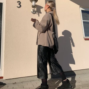 Vida läderbyxor från H&M - (2:a bilen lånad) Snygga vida läderbyxor från H&M köpta inför nyår för 299:- men kom aldrig till användning och inte nu heller.  Formar midjan och höfterna fint och materialet är stretchigt, passar både S/M. Köparen står för frakten.