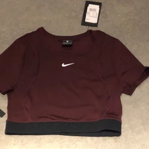 Ny Nike topp - Säljer en helt ny cropped top från Nike. Helt ny med lapparna kvar. Fin vinröd färg. Storlek S. Nypris 429kr, säljer den för 300kr. 
