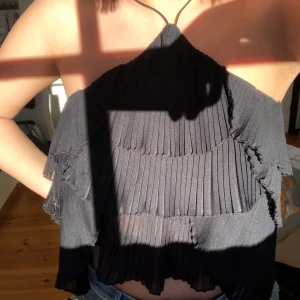 Halterneck topp - Fin topp med volanger från Zara. Den knyts i nacken med två tunna straps. Superfin att ha under jacka eller utan nåt över! Använd endast på bilden! Frakt: 40 kr.