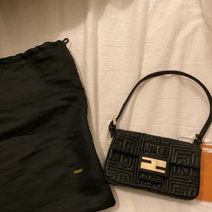 Äkta Fendiväska - En äkta fendiväska som säljes pga att den aldrig används. Den har en speciell insida och är också av läder och inte av canvas, vilket gör väskan väldigt speciell. Den är köpt från Vestiaire Collective och därmed kommer det med en kontroll av väskan från dem. Kommer med dustbag och ett till band för att kunna ha crossbody🤩Meddela om fler bilder skulle önskas😊🌟