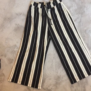 Byxor från ginatricot - Snygga byxor från gina. Svarta och vita ränder. Står att det är en meduim men skulle söga att den passar bättre som xs-s