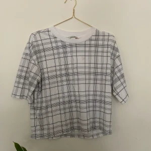 Rutig T-shirt - T-Shirt från Monki. Väl använd, har en liten fläck över bröstet som inte vill försvinna. Syns knappt om man inte vet att den är där😁 Frakt tillkommer✨