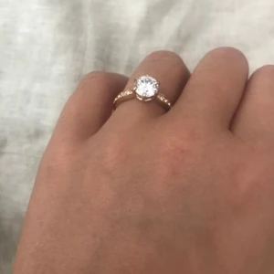  - Aldrig använd endast provad ring med stor sten i mitten och några på vardera sida. Storleken passar 16-16,5mm. Frakt är inkluderat i priset.