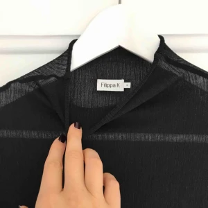  - Svart transparent topp från Filippa K SS18 som passar XS-S. Använd vid ett tillfälle. Hittade bara en bild med den ljusa på