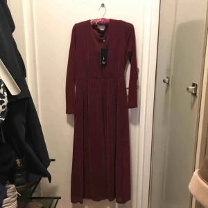  - En glittrig vinröd långklänning från Sisters Point (köpt från Nelly), stretchiga material som aldrig har använts!   Jag möts helst upp i stan (Stockholm) men kan även skicka paket, då står köparen för frakten!   Pris kan diskuteras vid snabb affär!
