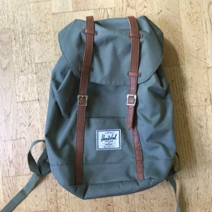  - Olivgrön ryggsäck från Herschel! Rymlig med breda axelband, ett stort fack och ett vadderat datorfack. Använd men i mycket bra skick, det enda är en liten fläck på märket (se sista bilden).  Möts i Uppsala eller så betalar köparen frakten! 