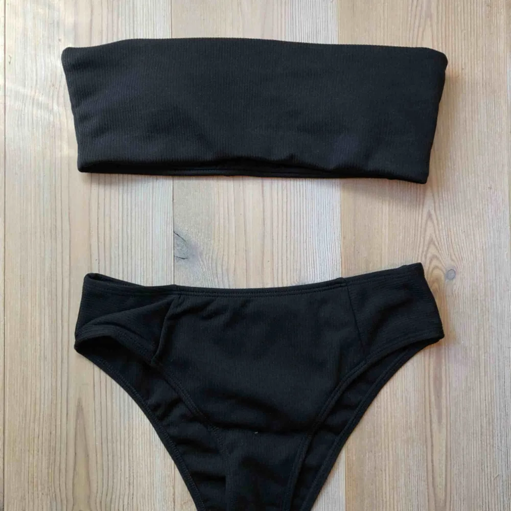 Ribbad svart bikini med högmidjad underdel och bandeau överdel. Aldrig använd.   Köparen står för frakt :). Övrigt.