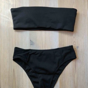  - Ribbad svart bikini med högmidjad underdel och bandeau överdel. Aldrig använd.   Köparen står för frakt :)