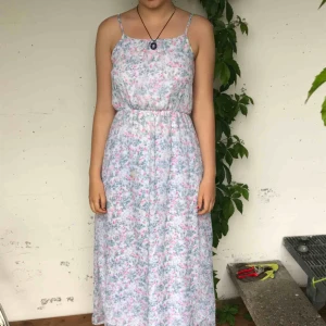  - En långklänning med vitt innertyg. 