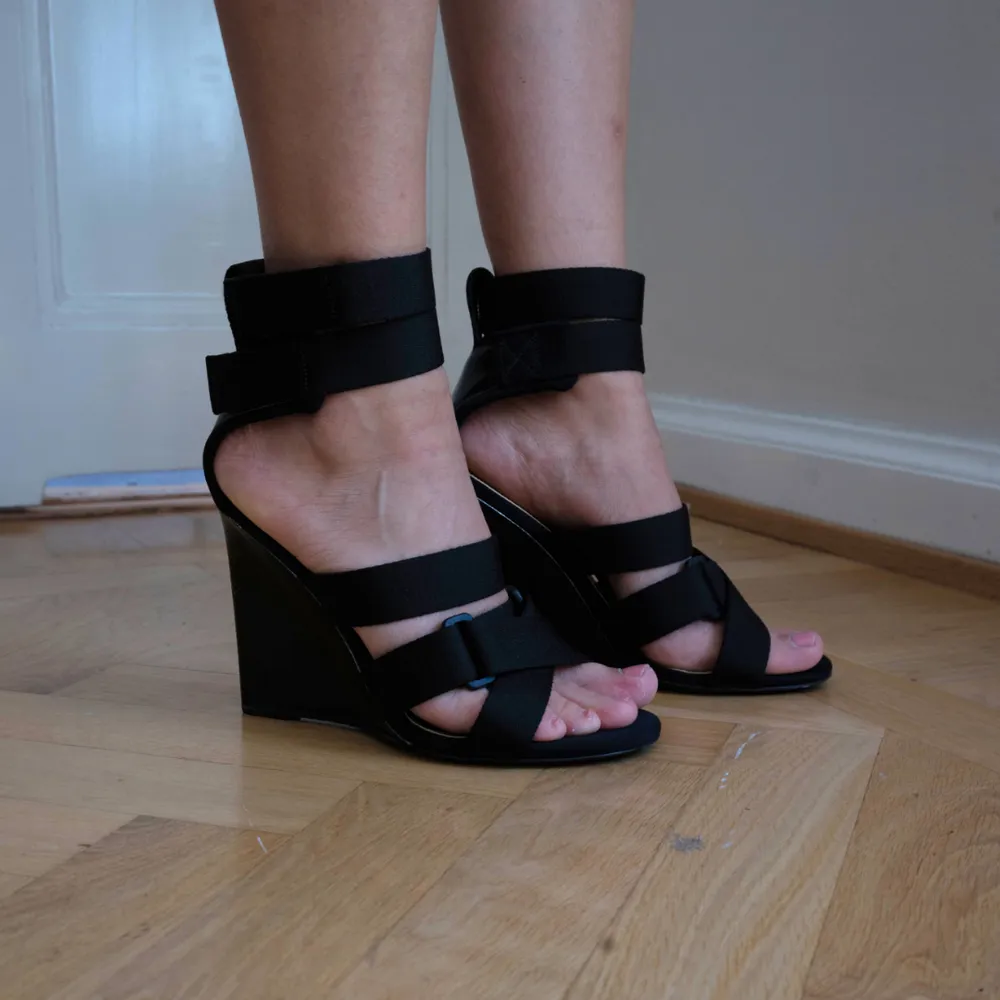 Unika sportiga sandaletter från H&M Studio runway SS17 med hög kilklack. Skorna bars av Gigi Hadid under visningen! Sandaletterna har remmar i nylon som stängs med kardborre och innersula i läder. Något slitna bak på hälen (se bild), annars fint skick.  . Skor.
