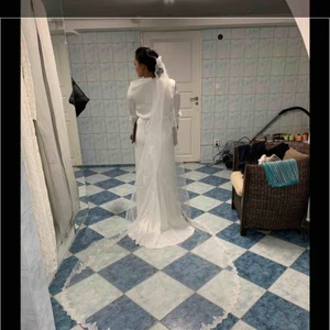  - Jättefin brudslöja med brodyr längs kanten. Ca. 300cm. Färg: Ivory. Oanvänd. Obs! Ingen ”kam” på slöjan. 