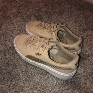  - Ett par Puma Plattform i bra kvalite. Använda 1-2 gånger. En mellan beige färg med guldiga detaljer. En lite högre sula. Inköpspris: 1200kr