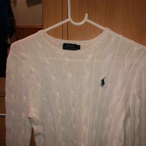  - Vit kabelstickad tröja från ralph lauren i väldigt fint skick. Säljer då den inte kommer till användning. Köpt för 1000 kronor, säljer för 350+frakt