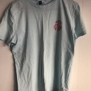 Ljusblå tröja från h&m - Snygg tröja från H&M i storlek XS. Texten på bröstet är ”travel state of mind” och tröjan är i ljusblå och texten i rosa. Frakten ingår i priset. 