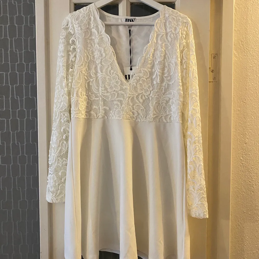 En vit klänning med spets upptill. Har aldrig använt den så prislappen är kvar. ( frakt tillkommer, om den ska skickas ) . Klänningar.