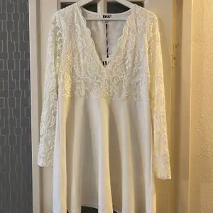 En vit klänning med spets upptill. Har aldrig använt den så prislappen är kvar. ( frakt tillkommer, om den ska skickas ) 