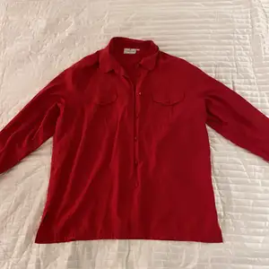Röd lång skjorta i strl L/XXL från Cappucini Framfickor och knappr finns. Aldrig använd. 