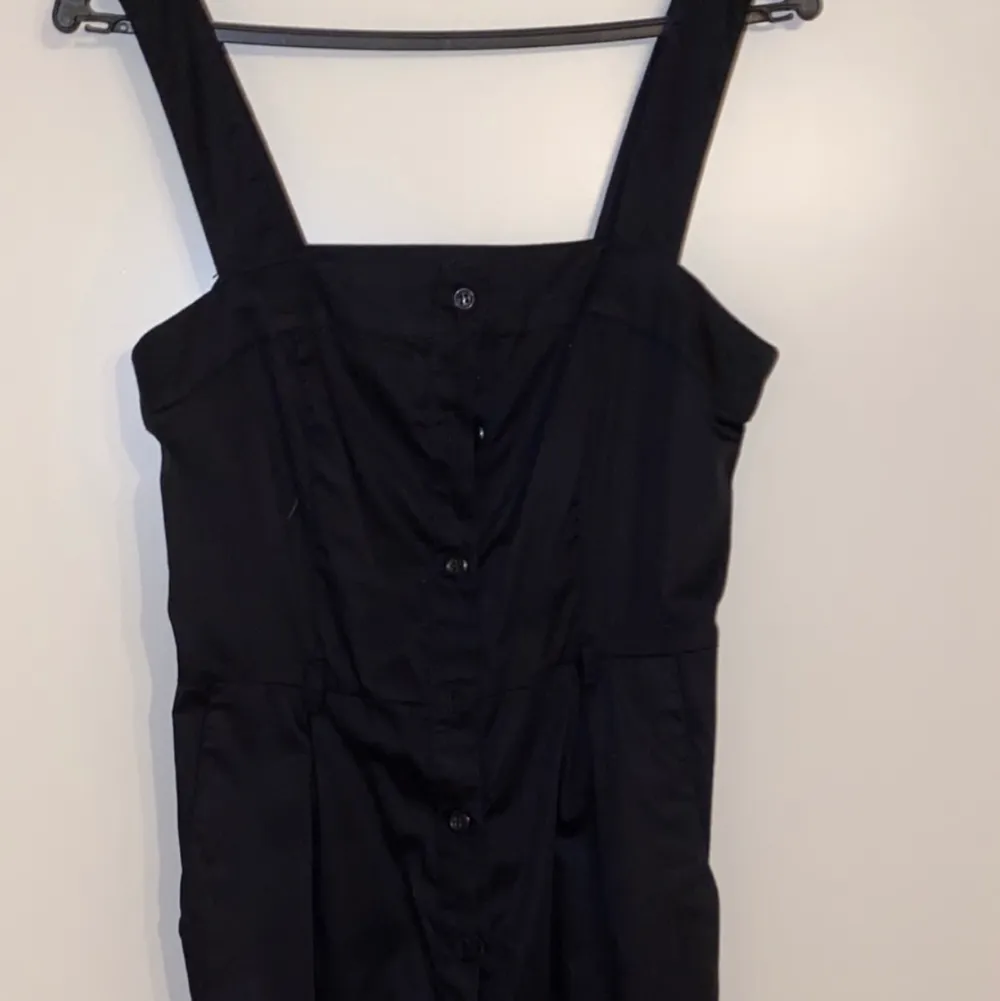 En svart klänning med knappar från h&m i storlek 38.. Klänningar.