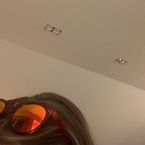 Solglasögon från BikBok i rött/orange/gul - Solglasögon med röda bågar och orange/gult/rött glas. Skiftar i olika ljus