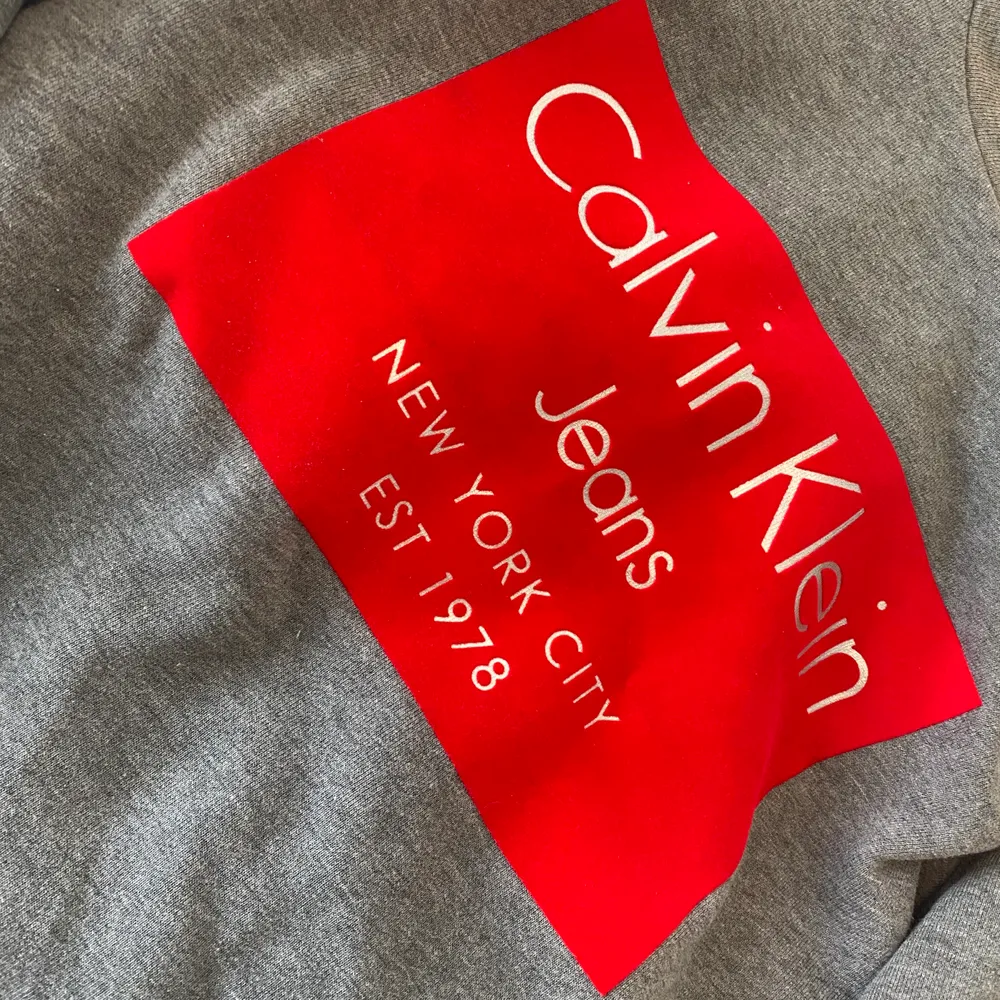 Grå Calvin Klein sweatshirt med rött märke på. I storlek XS men passar både XS och S. Inte använt speciellt många gånger!☺️💗. Tröjor & Koftor.