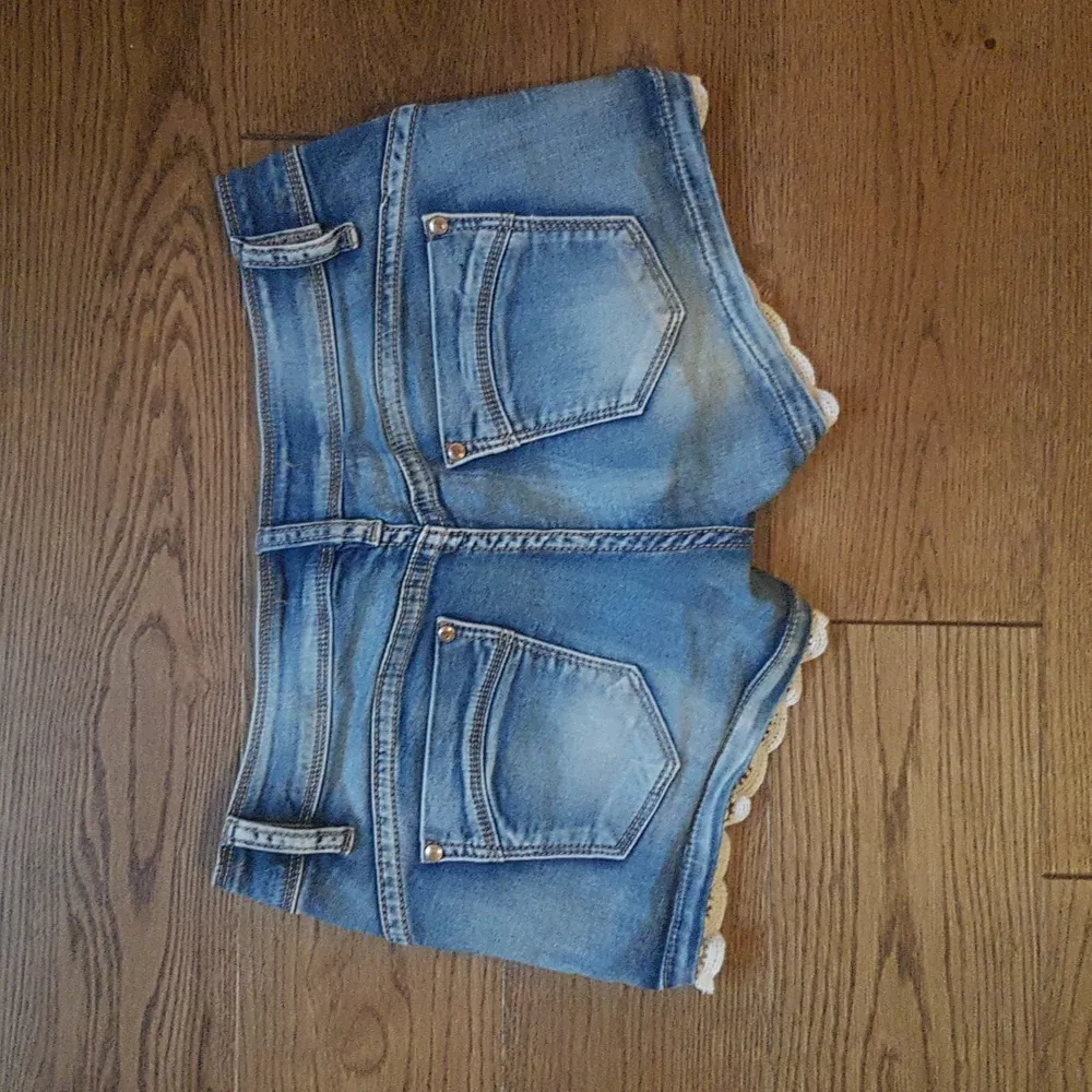 Söta jeansshorts med spetsdetaljer. Säljes då de är för små. Storlek M (obs små i storleken, passar nog s-xs). Frakt ingår.. Shorts.