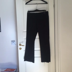  - Randiga utsvängda kostymbyxor som är avklippta vid fötterna