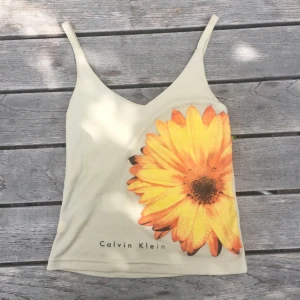  - Calvin Klein-linne med blomma. Små slitningar, se sista bild. 50 kr inklusive frakt :)
