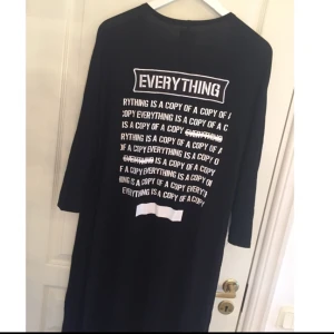  - Tunn svart vadlång kofta med tryck på ryggen och dragkedjedetaljer längs ärmarna. Från Sixth June Parisienne, löst sittande.