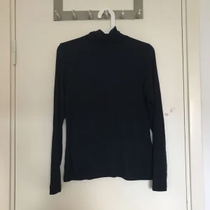  - En helt vanlig mörkblå polotröja i stretchigt material. Mycket lite använd och i fint skick. Tröjan sitter löst på mig men den är lite för stor för mig.     Frakt ingår INTE i priset 