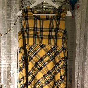  - Riktigt cool klänning i storlek M, 60-70/90-tals stil. Band som man kan knyta bak eller fram, snyggt med en vit polotröja under. Köparen står för frakten!