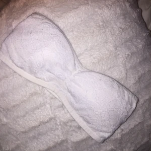  - En bandeau-bh i storlek 34, vit med spetsdetaljer. Även avtagbara laddar i! 🌟