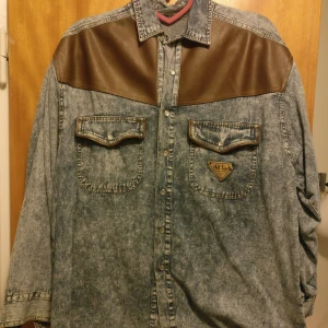  - En cool jeans skjorta med fake läder detaljer, super häftig och skön!   Mer som en stor M/L 