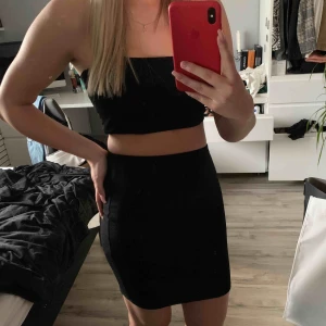 - Kjol med typ topp i set från Nelly, båda är i storlek S och som ni ser svarta. Materialet försöks visas på tredje och sista bilden, tillkommer frakt på 44kr och säljs ej separat! 