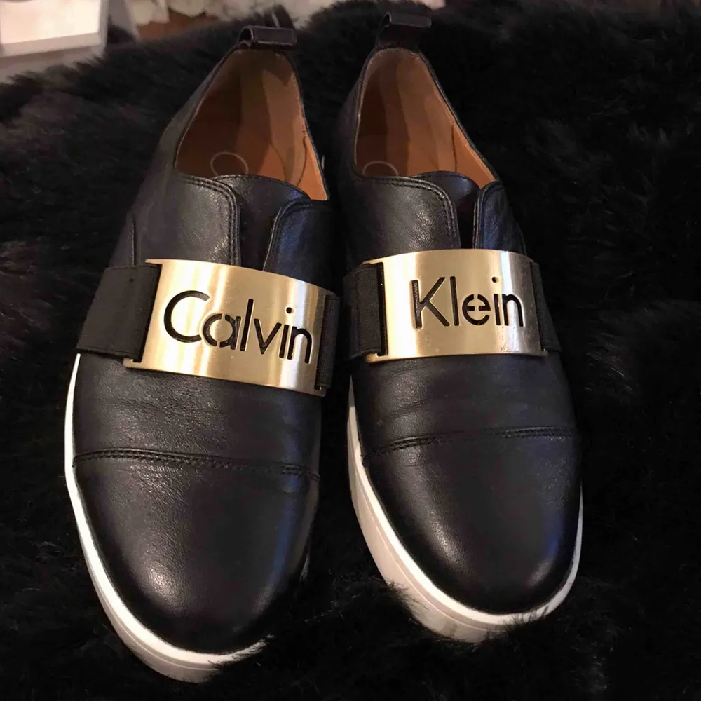 Svarta skin slip ins från Calvin Klein. Använda fåtals gånger.  Sulor med några blå märken, knappt synliga.. Skor.