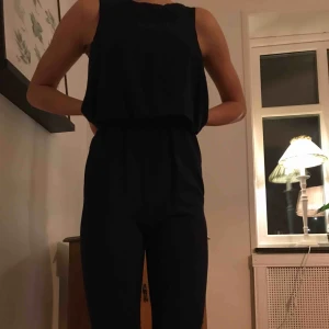  - Snygg mörkblå jumpsuit som tyvärr inte längre passar. Jag är 176 cm lång och den är för kort. Två fickor i fram och köpt för något år sedan.