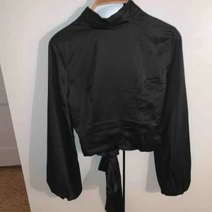  - Tröjan är från boohoo. Det är en silkes tröja men öppning i ryggen och snörning nedtill. Den är även lite polo vid halsen och har knappar där bak vid nacken. +frakt