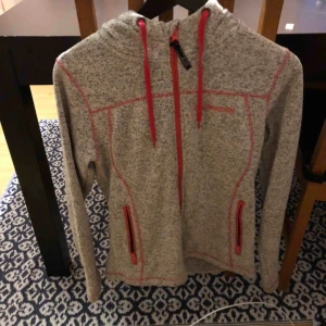  - Grå jacka med röda detaljer från bluewear, storlek S och i bra skick. Köparen står för frakten.